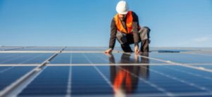 man on roof with solar panels